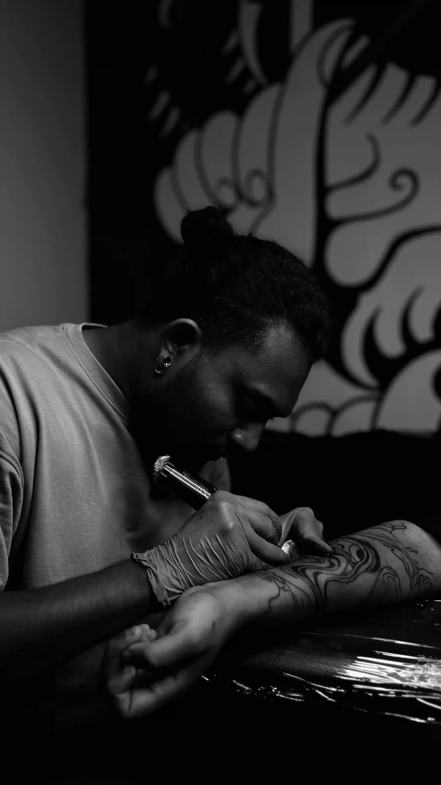 Portrait of a skilled tattoo artist working o a client,showcasing fine detailig-trused tattoo artist in kerala